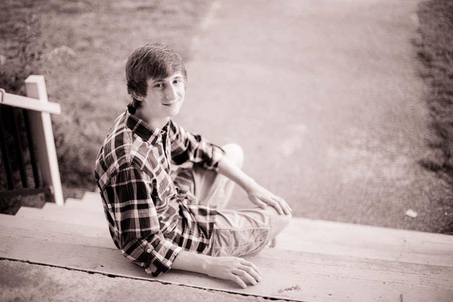 black and white of teenage boy sitting on steps