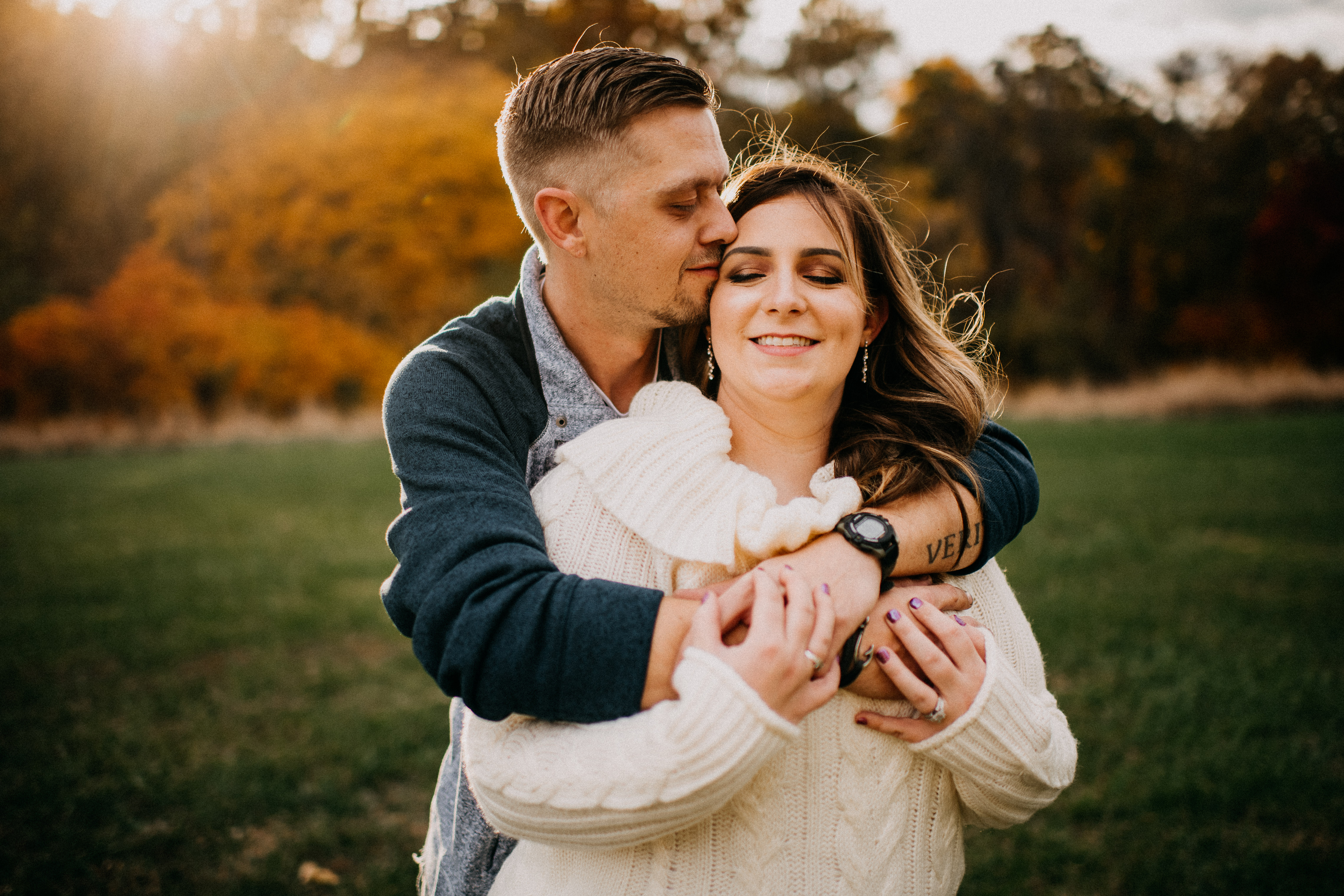 man hugging woman during fall engagement session at Faust Park