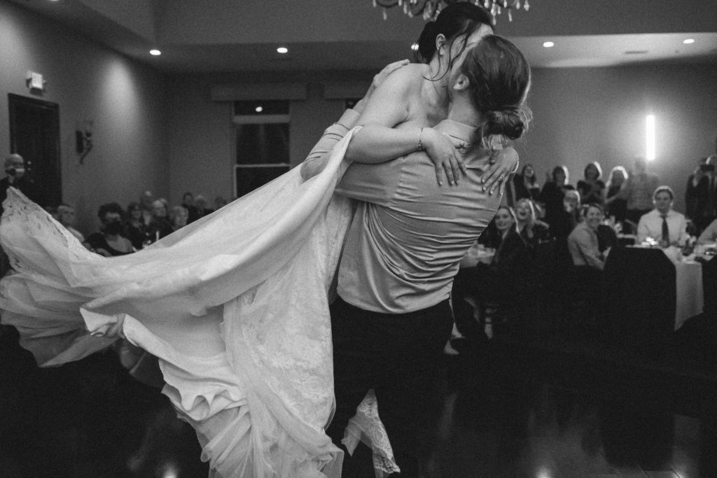 groom spins bride around the dance floor during their unplugged wedding reception